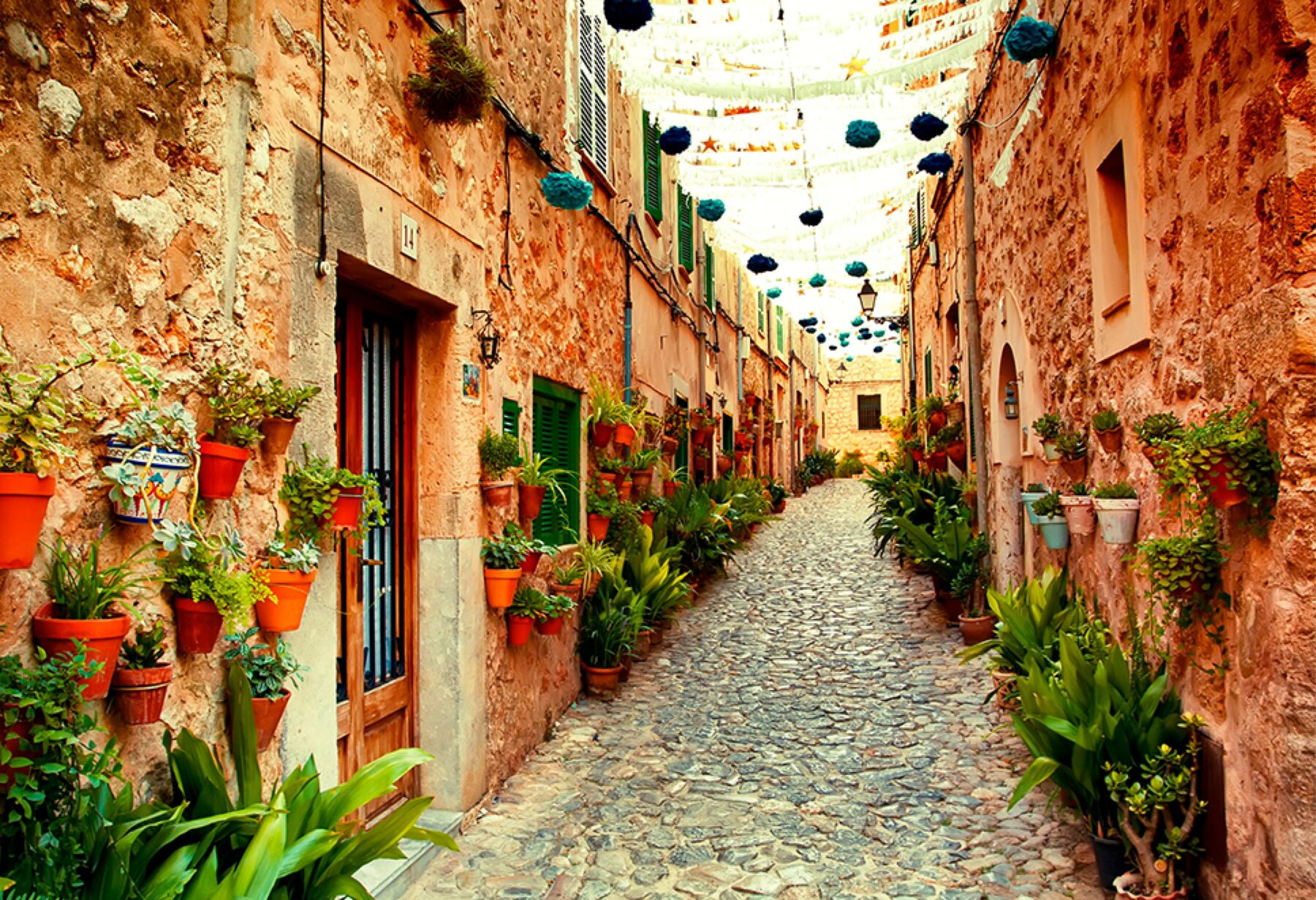 Narrow cobbled street in Spain with decorations hanging